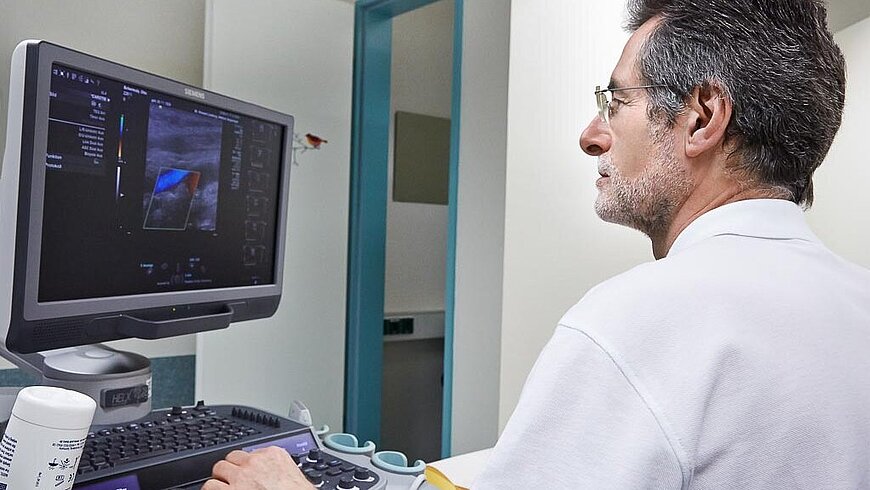 Ein Arzt untersucht mittels Ultraschall einen Patienten mit Verdacht auf Bauchaortenaneurysma.
