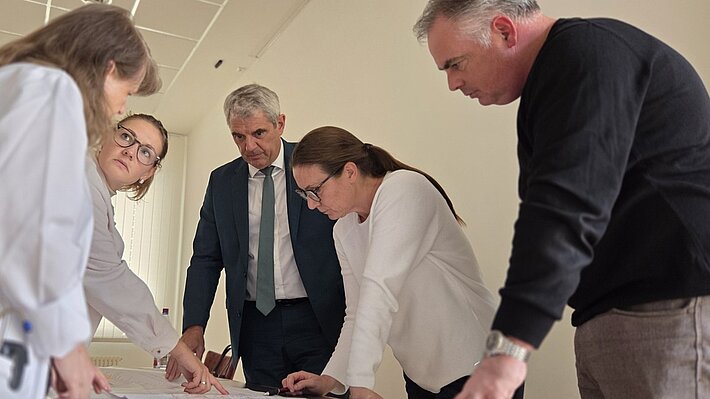 Die Planungsgruppe betrachtet die Baupläne.